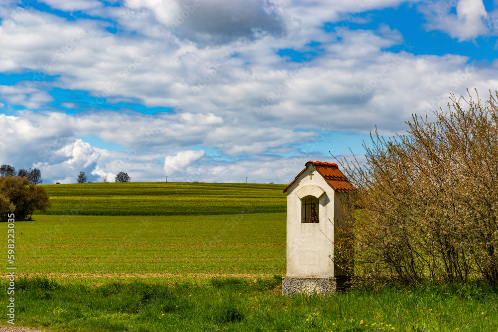 Small chapel in springtime field.