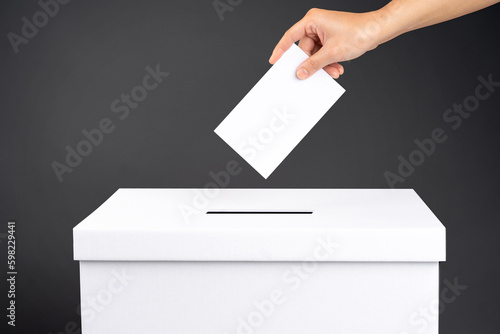 Cuadro en lienzo Female voter holds vote ballot paper in her hand above vote ballot for casting v