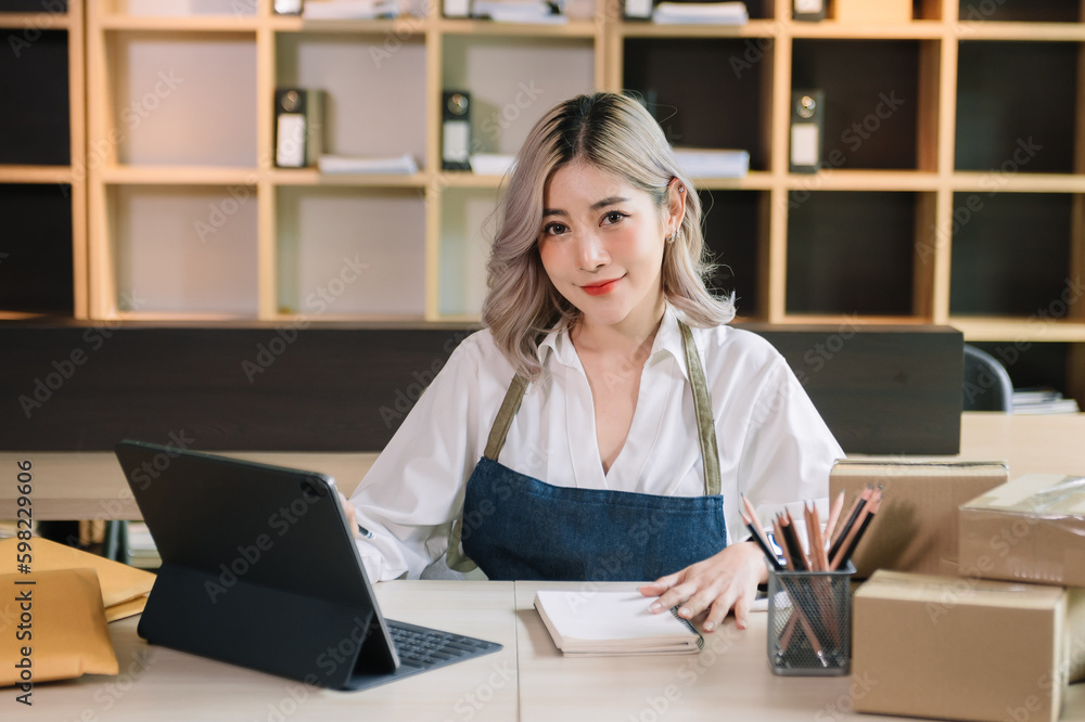 Small business entrepreneur SME freelance woman working at home office, BOX,tablet and laptop online, marketing, packaging, delivery, e-commerce concept.. Small business entrepreneur SME freelance woman working at home office, BOX,tablet and laptop online, marketing, packaging, delivery, e-commerce concept..