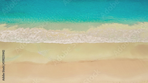 Beach and azure sea with waves from top view.