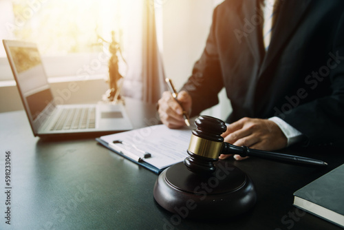 Business and lawyers discussing contract papers with brass scale on desk in office. Law, legal services, advice, justice and law concept picture with film grain effect