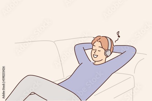Man listens to music lying on couch with headphones and enjoys cool audio sound of favorite track Generative AI