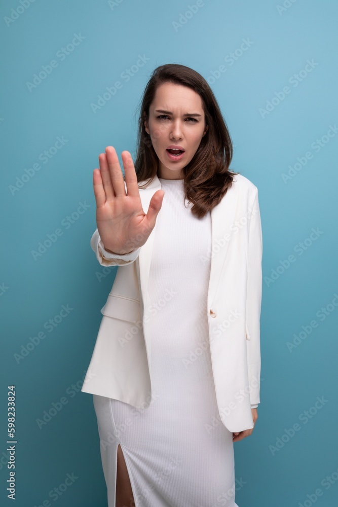 upset pretty brunette young woman in dress and jacket with grimace upset pretty brunette young woman in dress and jacket with grimace