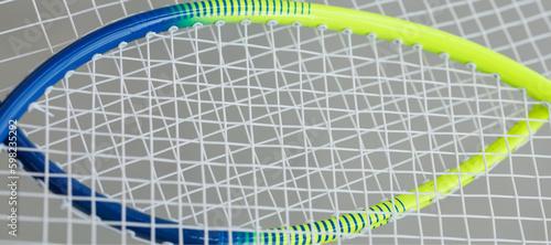 crossed yellow and blue tennis rackets with stretched cuts © Anna