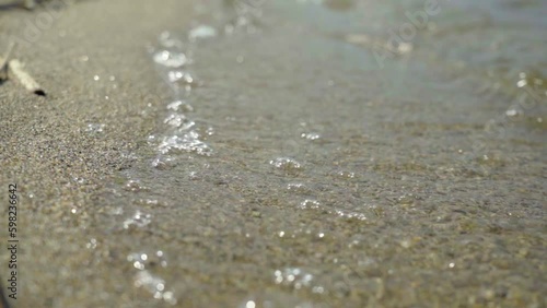 Wallpaper Mural A close-up of the soft waves of lake water lapping the sandy shore. Generative AI Torontodigital.ca