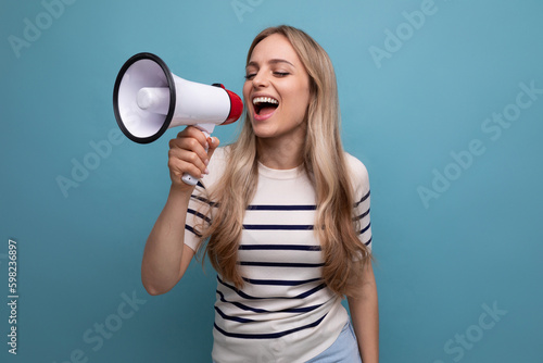 bright blond woman speaks into a megaphone about a profitable offer at a sale on a blue background