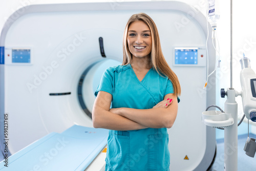 Beautiful happy female doctor physician radiologist standing in CT CAT Scan room at hospital.