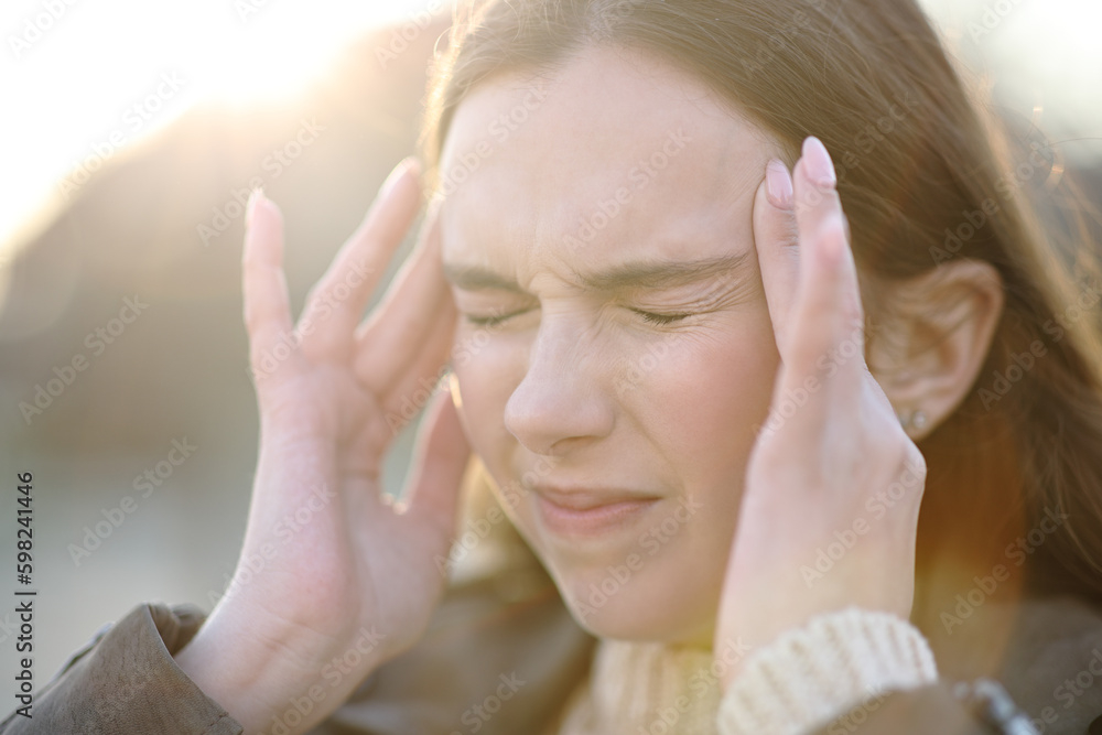 Woman suffering head ache outdoors and complaining Woman suffering head ache outdoors and complaining
