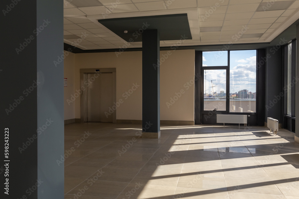 Fototapeta premium A large, spacious, empty room with huge windows and floor-mounted central heating radiators with temperature controllers.