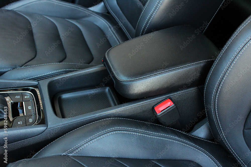 Obraz premium Armrest in the car for driver. Car armrest. Car armrest opened. Opened armrest in the car for driver.
