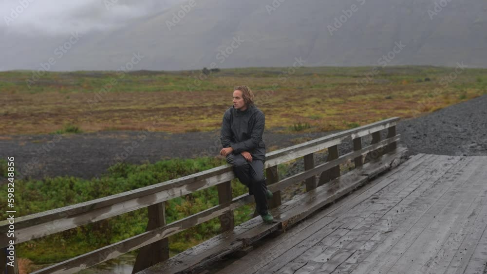 Man Sitting On A Mountainside Bridge Man Sitting On A Mountainside Bridge