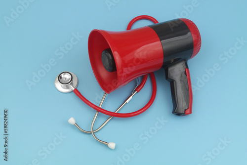 Important medical and healthcare information concept. Loudspeaker with stethoscope on blue background.