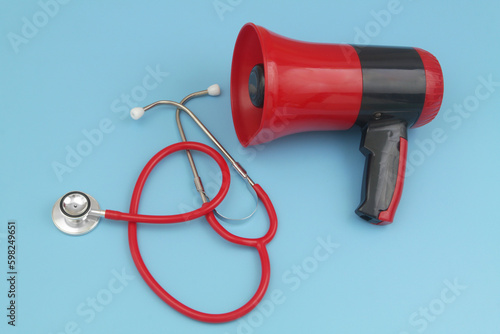 Red stethoscope and red megaphone on blue background.