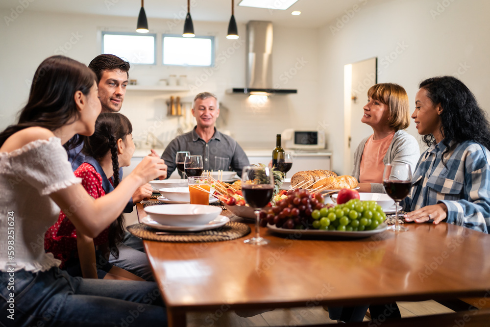 Multi-ethnic big family having dinner, enjoy evening party in house. Multi-ethnic big family having dinner, enjoy evening party in house.