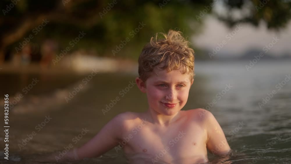 Boy Smiling While Swimming At The Beach Boy Smiling While Swimming At The Beach