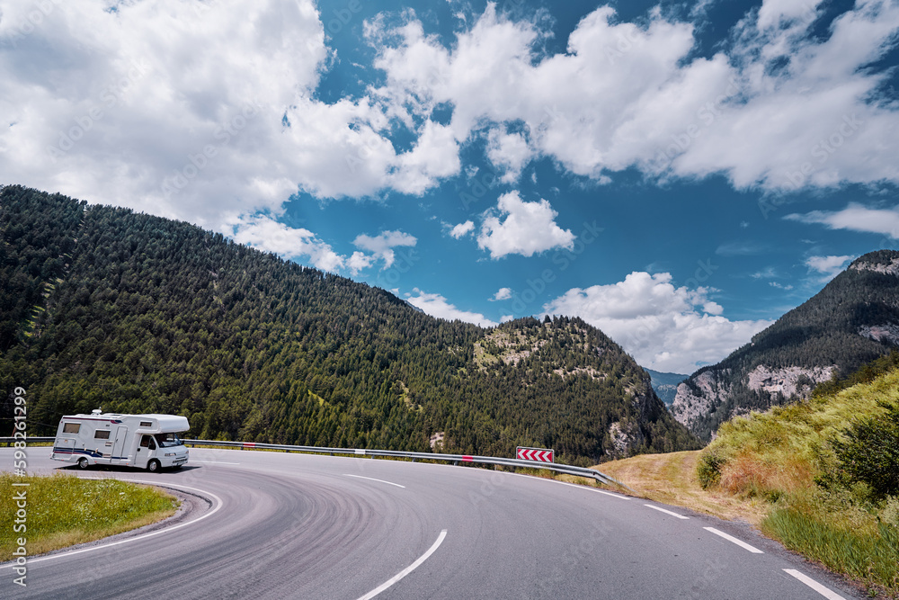 Caravan car travels on the highway in Alp Mountains. Traveling concept. Camper vans.