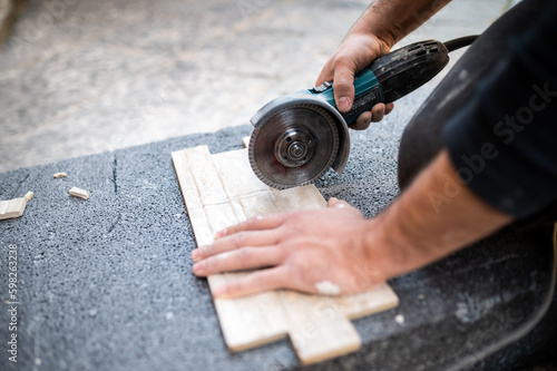 Closeup of a worker use cutting machine to cut a ceramic tile