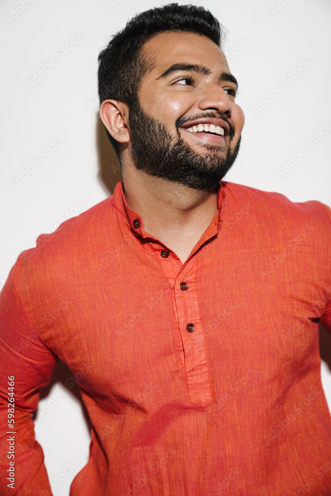 Indian man smiling and looking away while standing isolated over white background Indian man smiling and looking away while standing isolated over white background