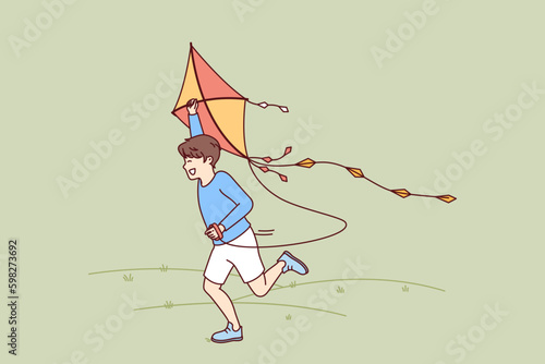Little boy with kite runs through meadow enjoying summer walk with favorite toy. Happy kid laughing while flying kite for concept of carefree childhood and teen outdoor activity Generative AI