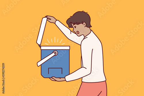 Surprised man opens portable refrigerator for ice cream or drink and is shocked to see contents. Young guy with portable refrigerator yells wow sees cool drinks for picnic or camping Generative AI