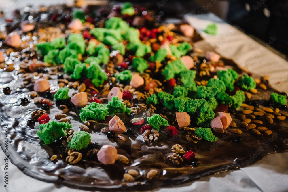 Hand made chocolate with nuts, almond, walnut, cream, candies, jelly and decor. Cooled liquid nitrogen on hot chocolate. Chocolatier сooking, cooling melted mass. Closeup Hand made chocolate with nuts, almond, walnut, cream, candies, jelly and decor. Cooled liquid nitrogen on hot chocolate. Chocolatier сooking, cooling melted mass. Closeup