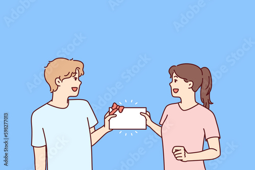 Man and woman with gift certificate in hands rejoice at receiving invitation card for advertising promotion. Happy couple holding certificate with gift bow or discount coupon for bargain Generative AI