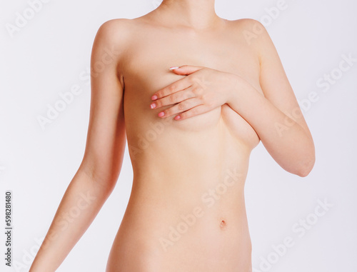 A naked female body with a covered breast on a white background. The concept of female breast cancer.