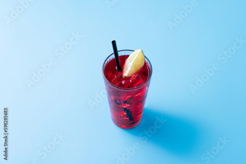 Cape Codder cocktail with vodka, cranberry juice and lime on blue background