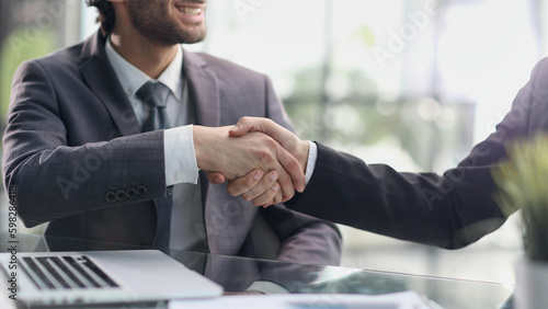 man Manager welcomes the client with a handshake. © Katsiaryna