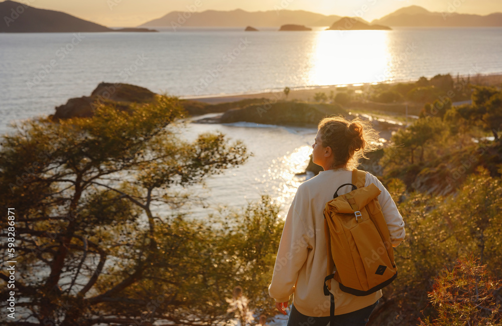 Fototapeta premium Travel and active lifestyle concept. Happy smiling woman hiking in mountains , Fethie, Turkey. Young female hiker smiling, sport and trekking in autumn or spring nature.