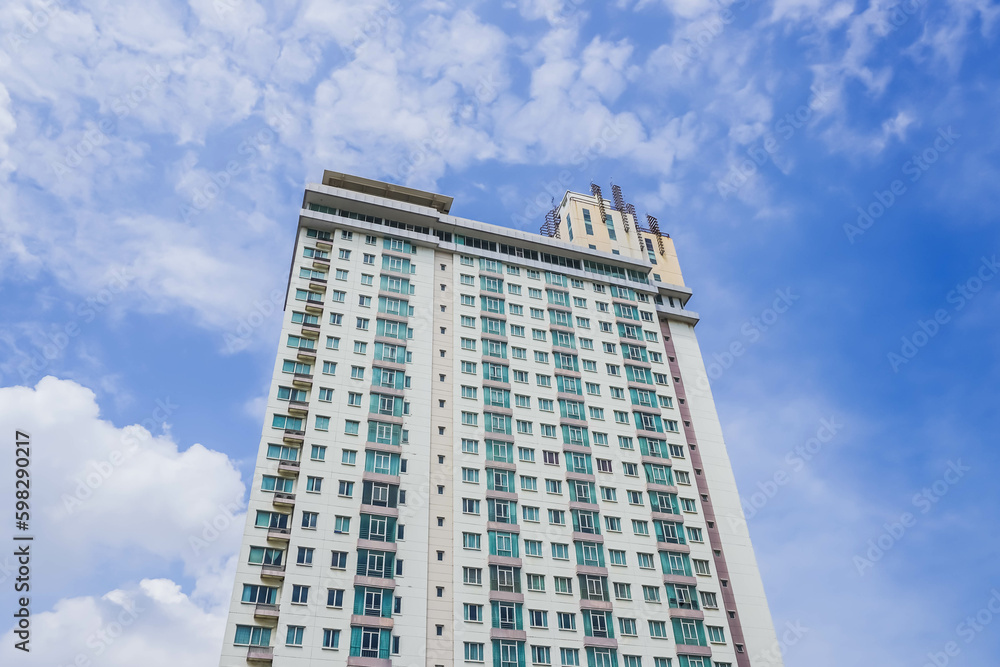 High-rise building photographed from below in the morning with clouds and blue sky background. High-rise building photographed from below in the morning with clouds and blue sky background.