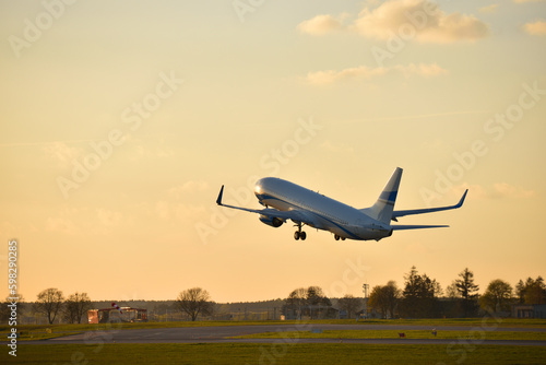 The plane takes off during sunset