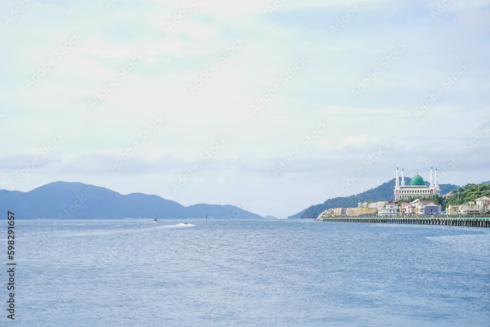 Fototapeta premium Tarempa, Anambas Archipelago, Riau Islands, Indonesia seen from the top of many buildings against a backdrop of blue ocean, islands, white clouds, clear sky in the morning.
