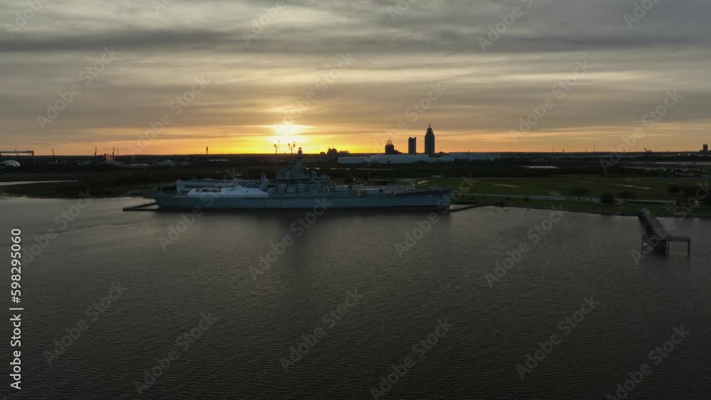 Pan view of the USS Alabama as the sun sets aerial view