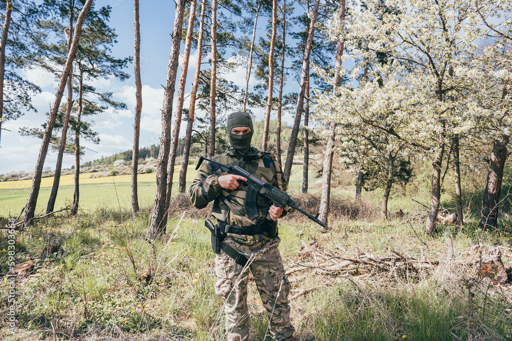 A member of a special unit. A soldier with an assault rifle in his hand and in uniform. Full tactical gear.A soldier in a forest in enemy territory A member of a special unit. A soldier with an assault rifle in his hand and in uniform. Full tactical gear.A soldier in a forest in enemy territory