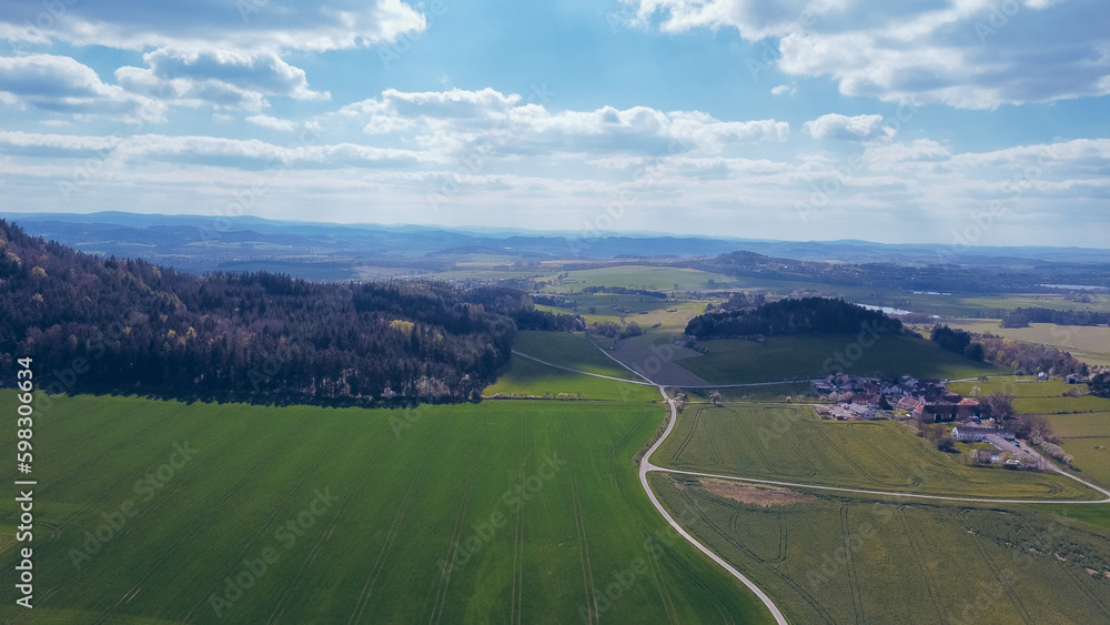 Green field, farmland with picturesque European landscape. Road in the middle of fields. Soft light. footage video drone view. in the background a range of mountains