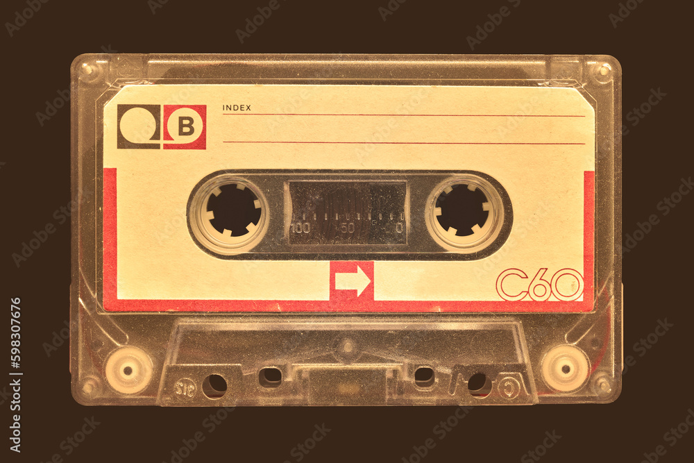 Vintage old audio compact cassette in front of a dark brown background