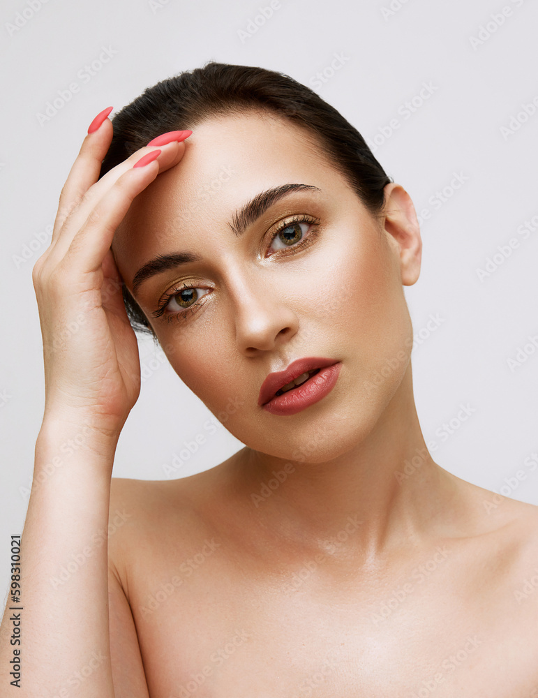Close up shot of attractive woman with perfect skin looking at camera with no emotions over white background. Model with well-kept, perfect skin