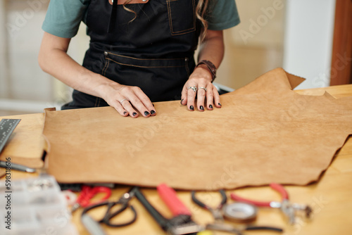 Creative young woman working with leather in her workshop