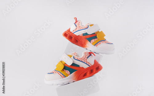 Baby sneakers, child sport shoes pair on white background. Fashion kids outfit. Fashionable sports shoes. Creative minimalistic layout with footwear mock up for your design. Advertising for shoe store