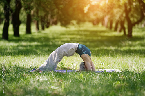 Young woman doing yoga exercise outdoor in the park, sport yoga concept