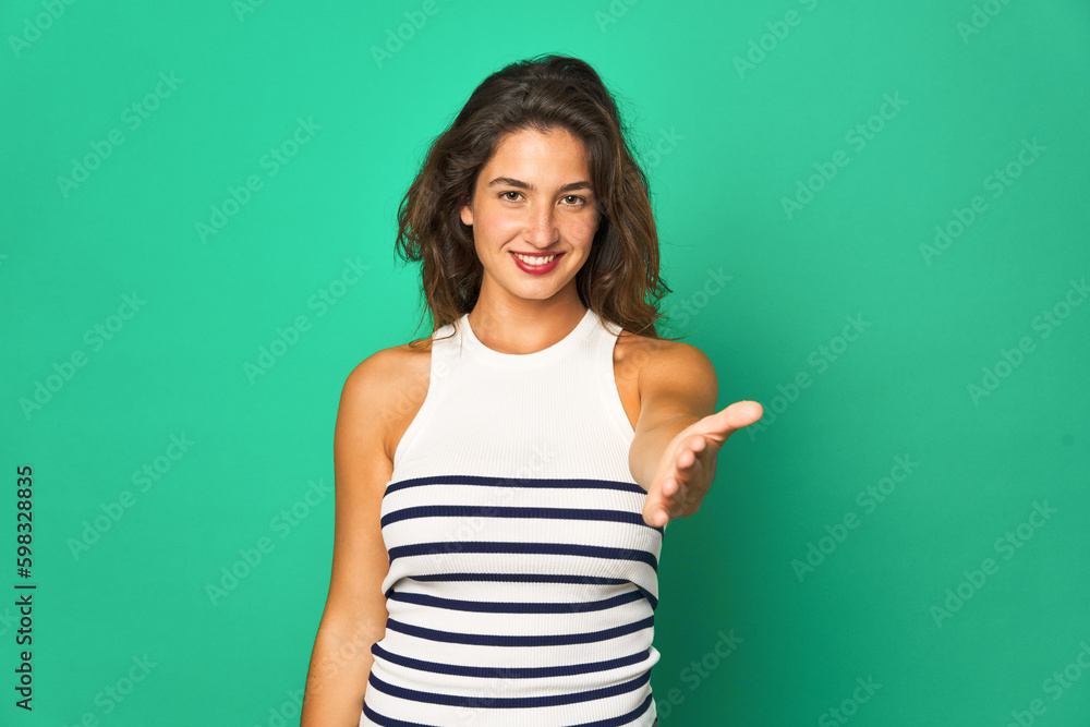 Young caucasian woman isolated stretching hand at camera in greeting gesture. Young caucasian woman isolated stretching hand at camera in greeting gesture.