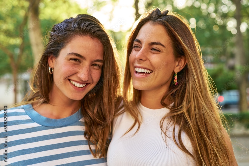 Fototapeta premium Two friends smiling happily in a park.