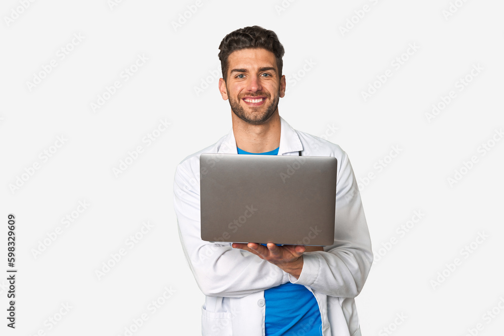 Young doctor man holding a laptop laughing and having fun. Young doctor man holding a laptop laughing and having fun.