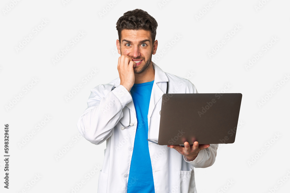 Young doctor man holding a laptop biting fingernails, nervous and very anxious. Young doctor man holding a laptop biting fingernails, nervous and very anxious.