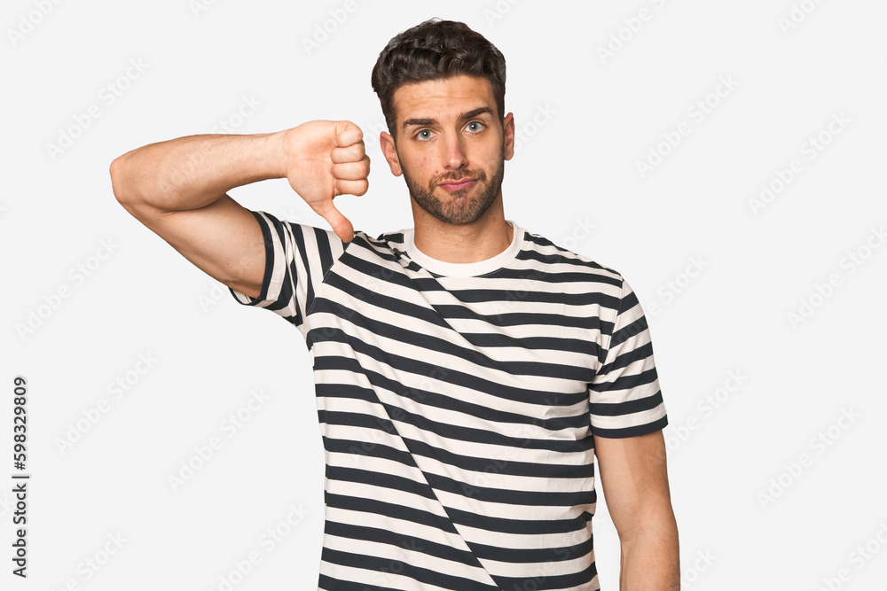 Young handsome man isolated showing a dislike gesture, thumbs down. Disagreement concept. Young handsome man isolated showing a dislike gesture, thumbs down. Disagreement concept.