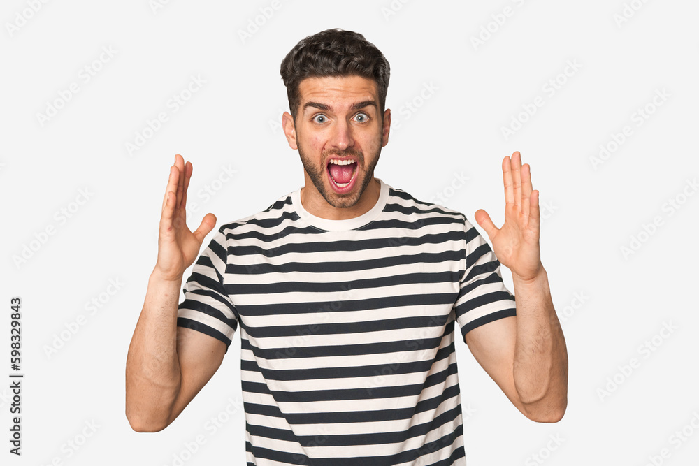 Young handsome man isolated celebrating a victory or success, he is surprised and shocked. Young handsome man isolated celebrating a victory or success, he is surprised and shocked.