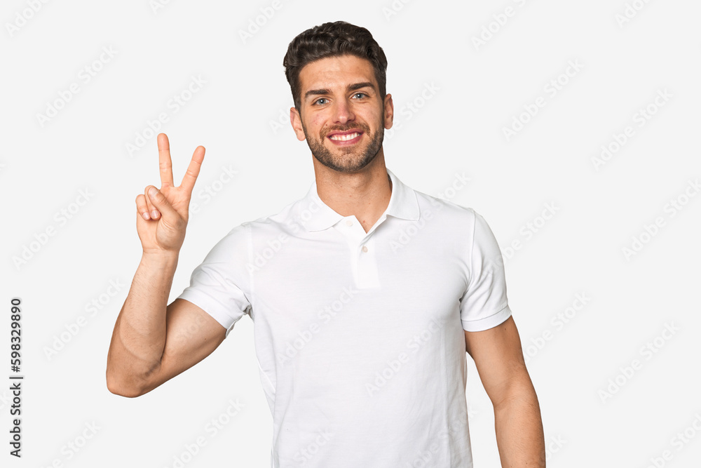 Young handsome man isolated joyful and carefree showing a peace symbol with fingers. Young handsome man isolated joyful and carefree showing a peace symbol with fingers.