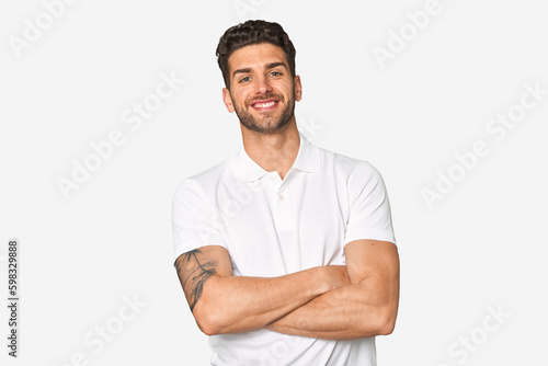 Young handsome man isolated who feels confident, crossing arms with determination. © Asier