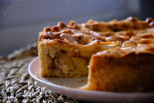shot of sliced apple pie on wicker background